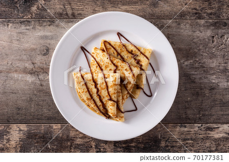 Sweet crepes with chocolate on wooden table 70177381