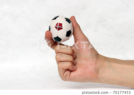Mini football in hand and one black point of football is Denmark flag 70177453
