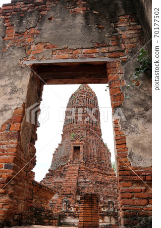 The Main Phra Prang or pagoda, the view through the door of church in the ruins of ancient remains The Main Phra Prang or pagoda, the view through the door of church in the ruins of ancient remains 70177502
