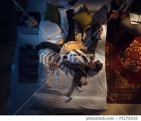 Portrait of a businessman, accountant sleeping in the bed at home Portrait of a businessman, accountant sleeping in the bed at home 70178320