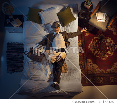 Portrait of a businessman, accountant sleeping in the bed at home Portrait of a businessman, accountant sleeping in the bed at home 70178380