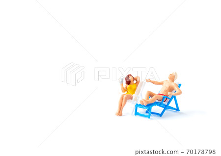 Miniature people sunbathing on deck chairs on white background , Summer time concept Miniature people sunbathing on deck chairs on white background , Summer time concept 70178798