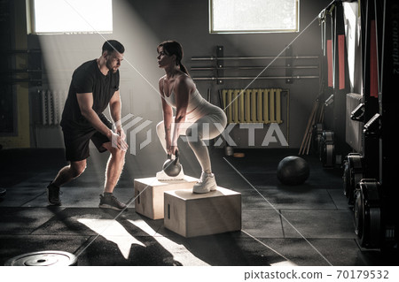 Athletic Woman Do Squat Exercise With Weight . 70179532