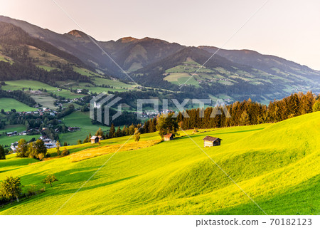 Romantic sunset in the mountains. Green alpine meadows and high peaks of Austrian Alps. Salzach River Valley, Pinzgau, Austria 70182123