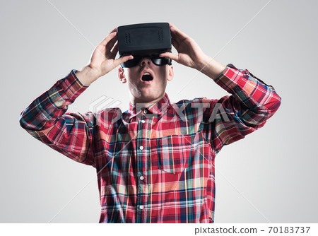 Guy in mask experiencing virtual reality as new entertainment device Guy in mask experiencing virtual reality as new entertainment device 70183737