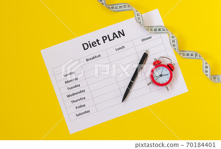 Diet schedule planner, measuring tape, pen and alarm top view 70184401