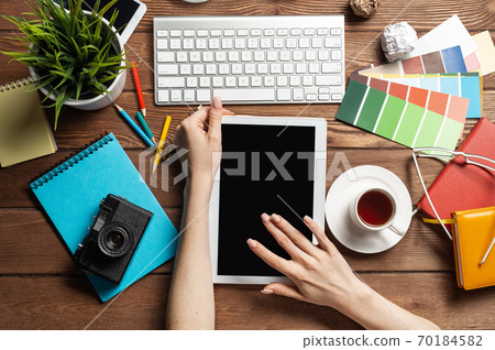 Freelancer sitting at desk and tablet computer Freelancer sitting at desk and tablet computer 70184582