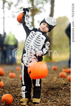 Little boy in scary skeleton costume at halloween celebrations party in forest.  70185026