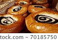 Sour cream buns swirl with poppy seeds closeup background. Sweet pastry. Apetite buns. Smetannik cookies famous in Russia, Belarus, Ukraine. Bakery products in rows are on the tray. 70185750