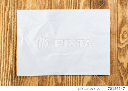 Sheet of paper lying on wooden table 70186247