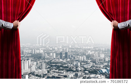 Modern business cityscape behind curtain opened by businessman hand 70186572