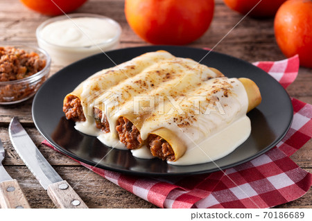 Delicious meat cannelloni pasta on wooden table. Delicious meat cannelloni pasta on wooden table. 70186689