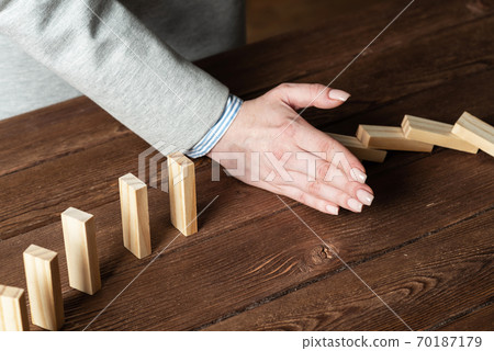 Business woman block domino effect. Business woman block domino effect. 70187179