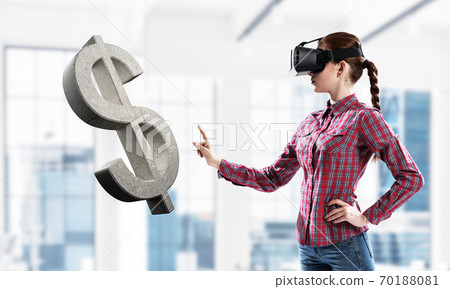 Girl in virtual reality mask experiencing virtual technology world. Mixed media 70188081