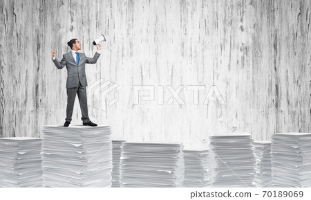 Businessman standing with megaphone. Businessman standing with megaphone. 70189069