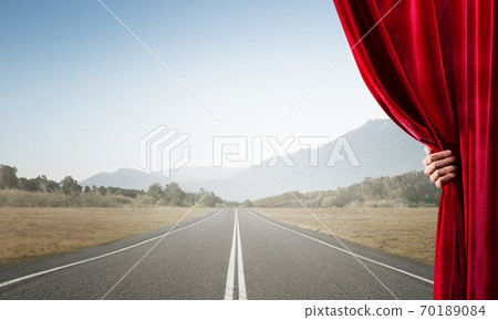 Asphalt road behind red curtain and hand holding it Asphalt road behind red curtain and hand holding it 70189084