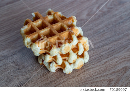 A delicious baked round Belgian waffle with one bite taken. 70189097