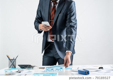 Businessman standing near office desk 70189327