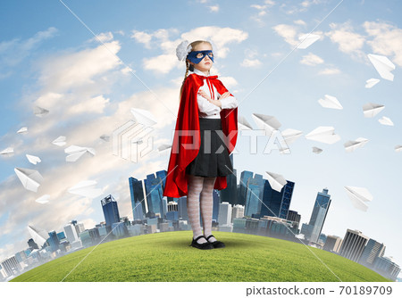 Girl power concept with cute kid guardian against cityscape background Girl power concept with cute kid guardian against cityscape background 70189709