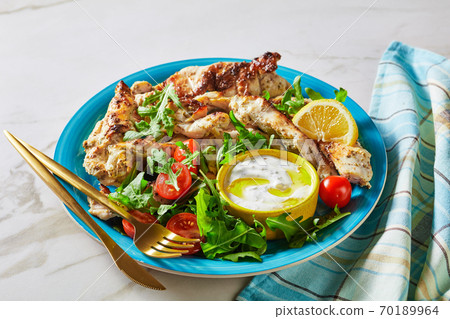Grilled chicken with arugula salad on a blue plate 70189964