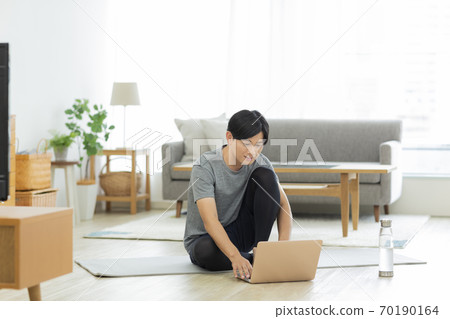 一個穿著訓練服的人,看著一台電腦 一個穿著訓練服的人,看著一台電腦 70190164