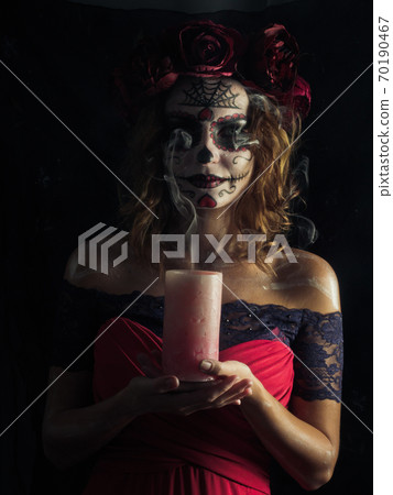 Santa muerte makeup young woman holding burning candle Santa muerte makeup young woman holding burning candle 70190467