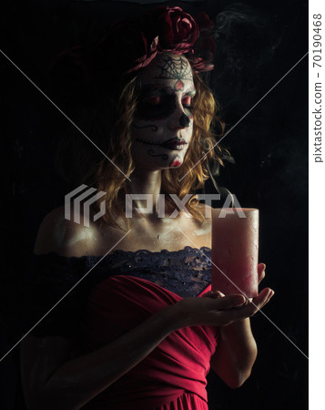 Santa muerte makeup young woman holding burning candle Santa muerte makeup young woman holding burning candle 70190468