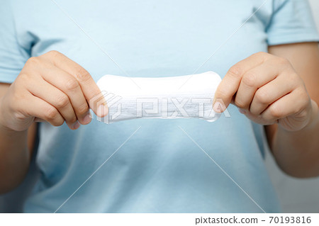 A woman carries a sanitary napkin, she is menstrual A woman carries a sanitary napkin, she is menstrual 70193816