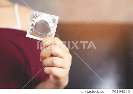 Condom ready to use in female hand, give condom safe sex Condom ready to use in female hand, give condom safe sex 70194900