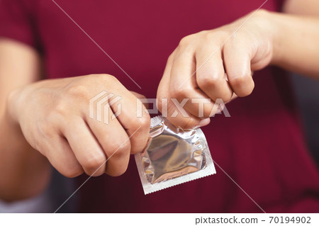 Condom ready to use in female hand, give condom safe sex Condom ready to use in female hand, give condom safe sex 70194902