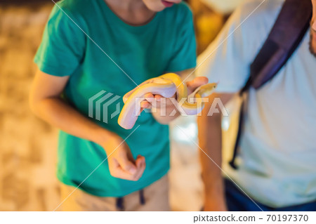 Smiling boy holding python in his hands 70197370