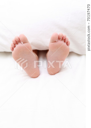 赤腳的一個女孩在床上睡覺 70197470