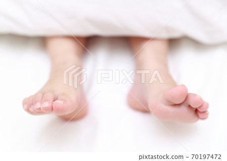 赤腳的一個女孩在床上睡覺 70197472