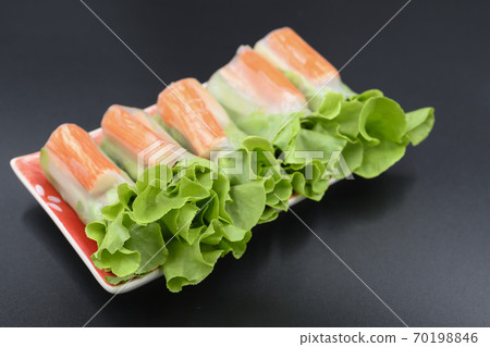 Vegetable salad with crab sticks arranged in a white plate Vegetable salad with crab sticks arranged in a white plate 70198846