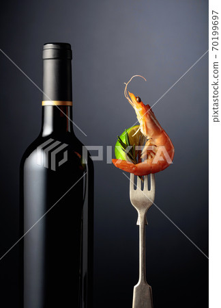 Bottle of wine and shrimp with rosemary and lime on a fork. Bottle of wine and shrimp with rosemary and lime on a fork. 70199697