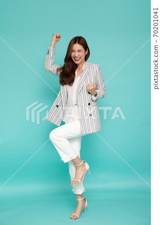 Attractive beautiful Asian woman standing and hands up raised arms from happiness. Attractive beautiful Asian woman standing and hands up raised arms from happiness. 70201041