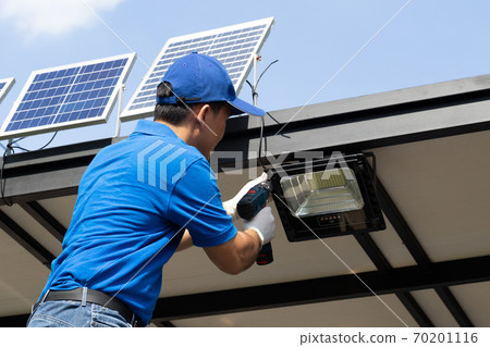 Asian workers technicians man installing solar photovoltaic panels for LED lamps . Asian workers technicians man installing solar photovoltaic panels for LED lamps . 70201116