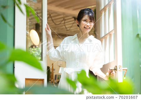 Young woman opening the front door Photo cooperation: Santome Konjyamura Young woman opening the front door Photo cooperation: Santome Konjyamura 70201607