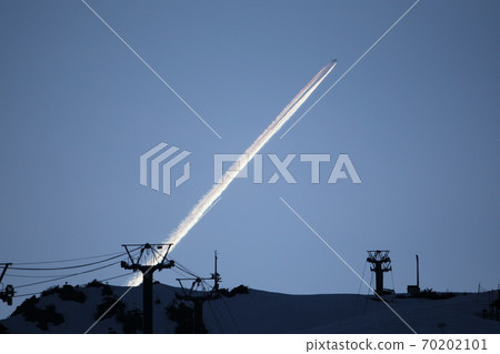 Contrails over the ski slopes at night Contrails over the ski slopes at night 70202101