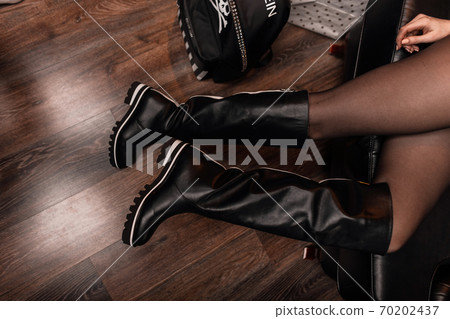 Top view on female legs in stylish leather boots Top view on female legs in stylish leather boots 70202437