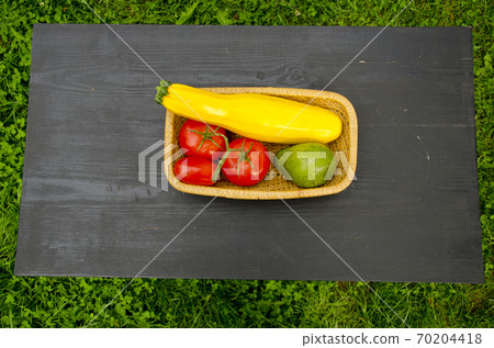 vegetables in wooden plate on black table 70204418