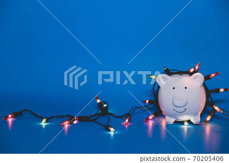 White piggy bank with Christmas string lights on happy December festival, Enjoy savings for spending money on the holiday's concept 70205406