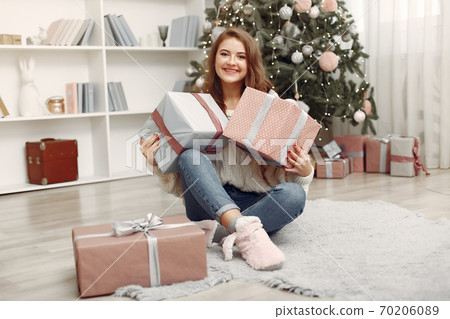 Girl with Christmas gifts in a decorated room 70206089