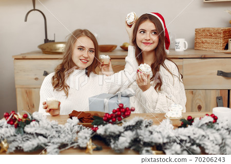 Two beautiful girls sitting at the New Year's table Two beautiful girls sitting at the New Year's table 70206243