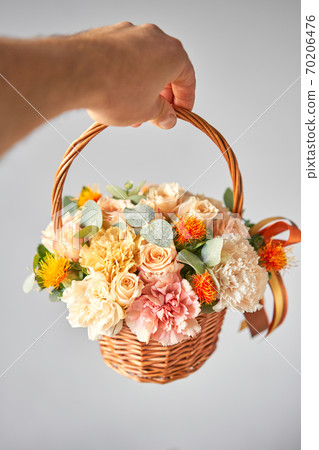 Small flower shop and Flowers delivery. Flower arrangement in Wicker basket. Beautiful bouquet of mixed flowers in woman hand. Handsome fresh bouquet Small flower shop and Flowers delivery. Flower arrangement in Wicker basket. Beautiful bouquet of mixed flowers in woman hand. Handsome fresh bouquet 70206476
