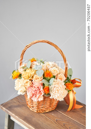 Small flower shop and Flowers delivery. Flower arrangement in Wicker basket. Beautiful bouquet of mixed flowers in woman hand. Handsome fresh bouquet 70206487