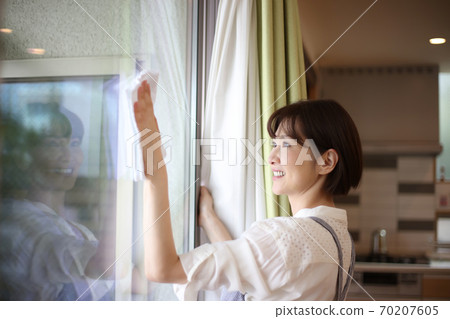 Woman cleaning the window Woman cleaning the window 70207605