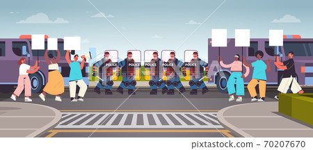 riot police officers controlling street protesters with placards during clashes demonstration mass riots riot police officers controlling street protesters with placards during clashes demonstration mass riots 70207670