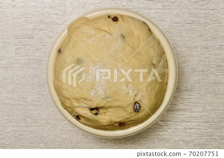 Airy yeast dough re-risen after adding raisins. Fermentation process of flour mixture with additives, with fillings. Airy yeast dough re-risen after adding raisins. Fermentation process of flour mixture with additives, with fillings. 70207751
