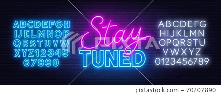 Neon sign stay tuned on brick wall background. 70207890